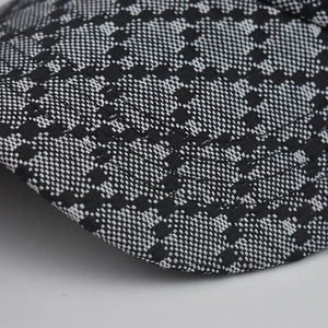 Macro detail of black and white checkered fabric with fine stitching on baseball cap