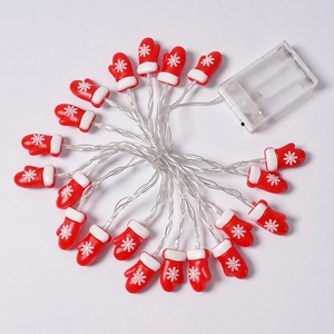 Macro detail of red Christmas glove LED string lights with snowflake pattern and battery box