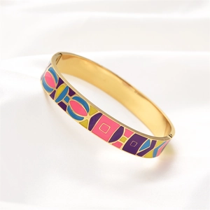 Detail of colorful geometric enamel patterns on a gold plated stainless steel bangle