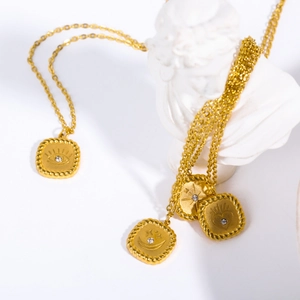 Vintage tarot pendants with sun, moon, eye, and heart motifs on a gold cable chain necklace