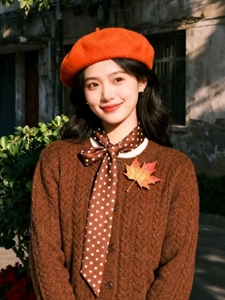 Thick orange wool beret with autumn knit cardigan and maple leaf decoration