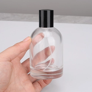 Flacone spray in vetro trasparente da 30ml con tappo nero mostrato in mano per profumo
