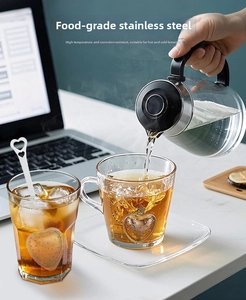 Detailed view of heart-shaped stainless steel tea infuser in a cozy home office setting