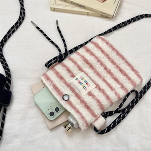 Detail view of pink striped plush crossbody bag with soft faux fur and braided strap