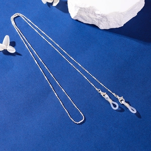 Silver beaded sunglasses chain with silicone loops on textured dark blue background