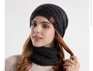 Détail du bonnet en tricot gris et tour de cou avec patch en cuir motif montagne