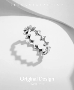 Close-up of geometric star pattern silver ring with polished finish and cutout details