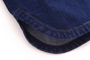 Detailansicht des abgerundeten Saums und Seitenschlitzes am dunkelblauen Jeanshemd mit Nähten