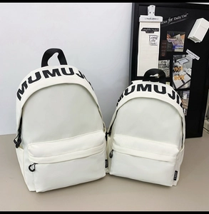 Detail of cream white backpacks with MUMUJI letter print handle in two sizes