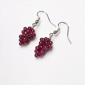 Macro detail of handmade burgundy garnet grape cluster earrings with silver ear hooks
