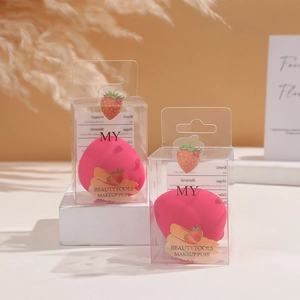 Set of two strawberry-shaped pink makeup sponges in individual transparent gift boxes