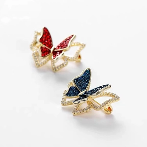 Exquisite golden butterfly brooches with red and blue zircon inlay on white background