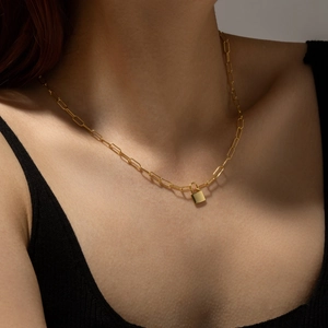 Modern gold paperclip chain necklace with a chic padlock pendant on female model