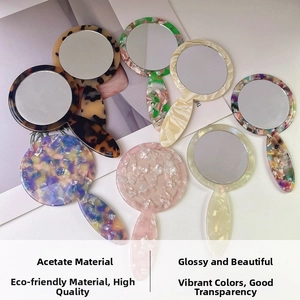 Flat lay of diverse vintage acetate handheld mirrors with shell and marble textures
