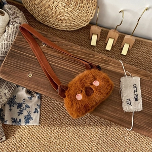 Detail view of small brown plush animal purse for kids with soft embroidery and strap
