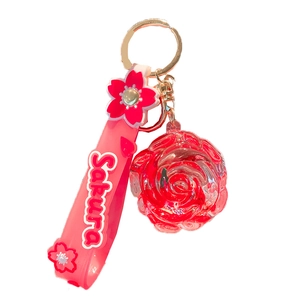 Pink sakura keychain with rose pendant and resin wristlet on white background