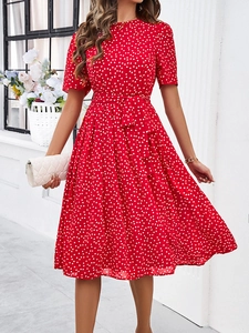 Détail d'une robe d'été rouge à pois blancs avec ceinture et manches courtes pour femme