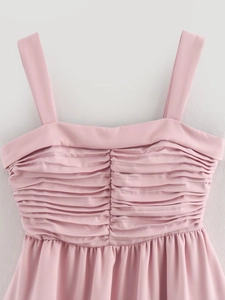 Close-up of ruched detail and thin straps on a light pink draped balloon mini dress