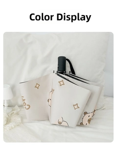 Close-up of a cream-colored folding umbrella with a cute Capy cartoon and star patterns