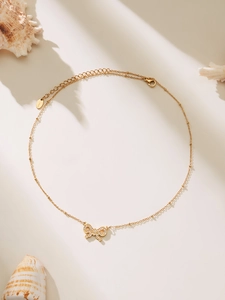 Detail of 18k gold plated bow pendant with cubic zirconia and S.Steel hallmark tag