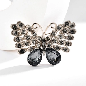 Detail of vintage butterfly brooch with dark grey crystals and silver metal frame