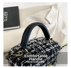 Detail van het handvat en de tweed textuur van deze modieuze zwart-witte emmer tas voor dames