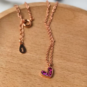 S925 sterling silver heart necklace with pink pavé crystals on a wooden surface