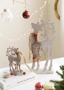 Detail of wooden Christmas elk decor with red berries on a festive table