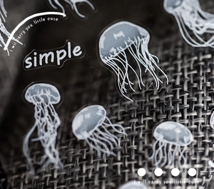 Macro shot of thin matte jellyfish nail decals with white ink on textured background