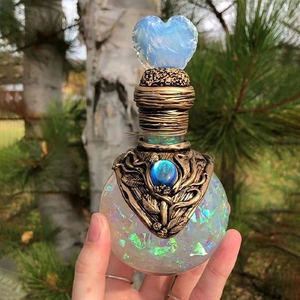 Decorative glass potion bottle with rainbow flakes and blue heart crystal stopper