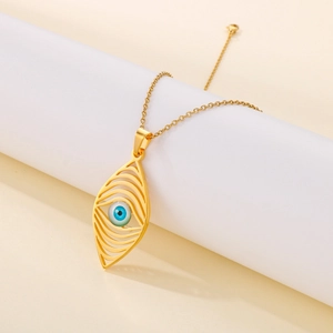 Detail of bohemian gold devil eye necklace with a blue eyeball pendant on a white pedestal