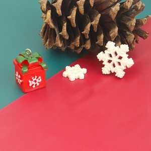 Close-up of glittery snowflake and red gift box charms for DIY Christmas resin crafts
