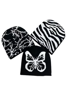 Three knit beanies with butterfly and zebra patterns displayed on a white background