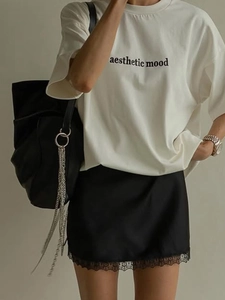White graphic T-shirt and black satin mini skirt with lace trim stylish summer outfit