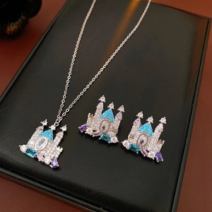 Dettaglio della collana con ciondolo a castello placcata in oro e orecchini con cristalli