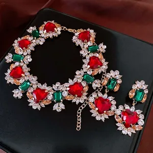 Luxury gold necklace set with red heart gems and green stones on a velvet display