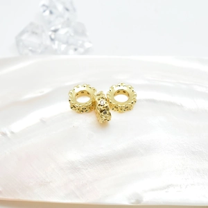Macro view of gold plated hollow flower spacers with white crystals for jewelry making