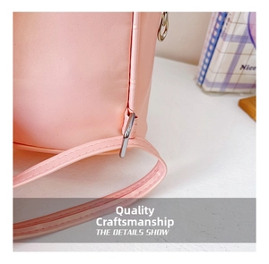 Close-up of pink leather stitching and metal hook detail on a girls' cartoon backpack