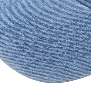 Gros plan de la visière en denim bleu délavé avec des coutures de renforcement parallèles