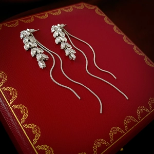 Close-up of vintage tassel earrings with marquise-cut zircons on a luxury red velvet box