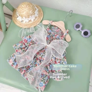 Detailed view of floral pet dress with layered ruffles and a large white organza bow