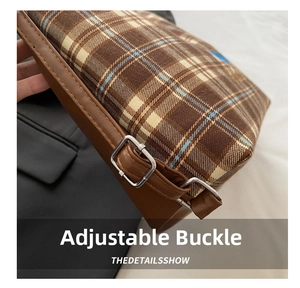 Detail of adjustable silver buckle and brown plaid strap on a large tote bag
