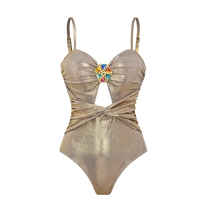 Close-up of champagne gold swimsuit featuring colorful gemstones and waist cutout detail