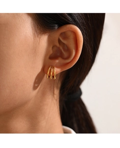 Side view of model wearing triple-layered C-shaped gold-plated stainless steel earrings