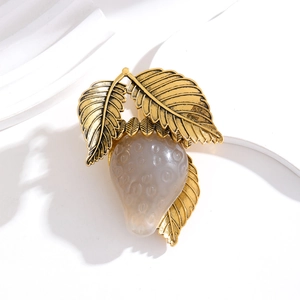 Vintage jelly resin strawberry brooch with gold metal leaves on white background