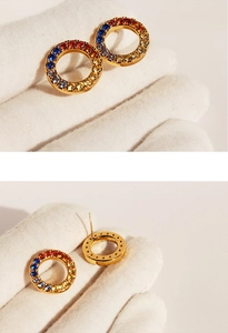 Macro detail of rainbow gradient cubic zirconia stones in golden round stud earrings
