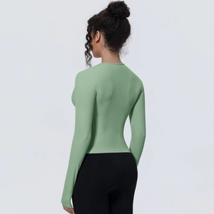 Haut de yoga manches longues vert sauge avec coupe ajustée et vue latérale athlétique