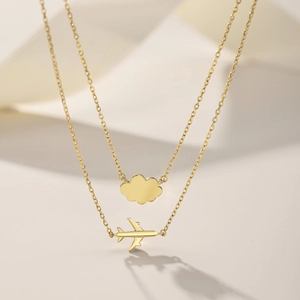 Detail of gold double-layer S925 silver necklace with airplane and cloud charms