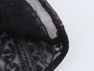 Nahaufnahme der schwarzen Spitzenstickerei mit floralem Muster und feinem Mesh-Gewebe