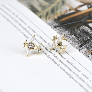 Elegant gold airplane stud earrings with sparkling white cubic zirconia on a minimalist base